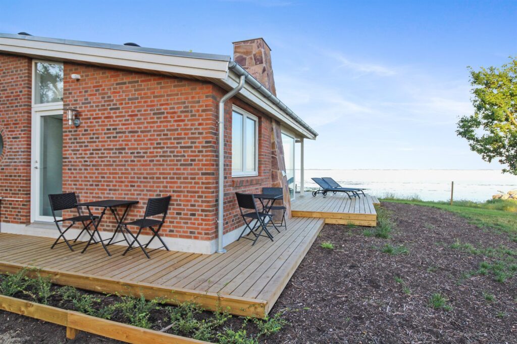 Träumen Sie von einem unvergesslichen Urlaub direkt am Meer? Dann ist dieses charmante Ferienhaus in Dänemark, genauer gesagt in Oure, genau das Richtige für Sie! Nur 10 Meter trennen Sie hier vom sanften Rauschen der Wellen und dem feinen Sandstrand – ein Paradies für Badefreunde und Naturliebhaber.

Unser Küstenhaus bietet mit 45 m² Wohnfläche und einem 320 m² großen Grundstück genügend Platz für bis zu 4 Personen. Das 2018 erbaute Haus ist modern und komfortabel eingerichtet. Genießen Sie entspannte Abende vor dem Kaminofen oder auf der 50 m² großen, teilweise überdachten Terrasse. Ein Sandkasten sorgt für Spaß bei den kleinen Gästen.

Im Inneren erwartet Sie ein gemütliches Wohnambiente mit Fußbodenheizung, WLAN und einem Fernseher, der eine Vielzahl an dänischen, schwedischen, norwegischen und deutschen Sendern bietet. Für Unterhaltung sorgen zusätzlich eine Musikanlage sowie ein CD- und DVD-Spieler. Die voll ausgestattete Küche lässt keine Wünsche offen: Hier finden Sie einen Kühlschrank, einen Gefrierschrank, einen Geschirrspüler, eine Mikrowelle und 4 Induktions-Kochzonen.

Die beiden Schlafzimmer sind mit Doppelbetten ausgestattet und bieten Platz für erholsame Nächte. Das Badezimmer ist mit einer Dusche ausgestattet, und eine Waschmaschine sowie ein Trockner stehen ebenfalls zur Verfügung. Ein besonderes Highlight ist der traumhafte Meerblick, den Sie von Ihrem Urlaubsdomizil aus genießen können.

Dieses Strandhaus ist ideal für Familien oder Paare, die einen entspannten Urlaub suchen. Auch Ihr Haustier ist bei uns herzlich willkommen. Für zusätzlichen Komfort sorgt eine energiesparende Wärmepumpe.

Dänemark.de bietet Ihnen nicht nur dieses wunderschöne Ferienhaus, sondern auch eine Bestpreisgarantie und den Dänemark.de-Bonus bei jeder Buchung. Treten Sie unserer Community auf Instagram bei und profitieren Sie von Inspirationen, Gutscheinen und Gewinnspielen!

Bitte beachten Sie: Das Ferienhaus wird nicht an Jugendgruppen unter 25 Jahren vermietet. Rauchen ist im Haus nicht gestattet. Eine Endreinigung kann optional hinzugebucht werden.

Buchen Sie jetzt Ihr persönliches Paradies und erleben Sie einen unvergesslichen Urlaub in diesem wunderschönen Ferienhaus in Dänemark!