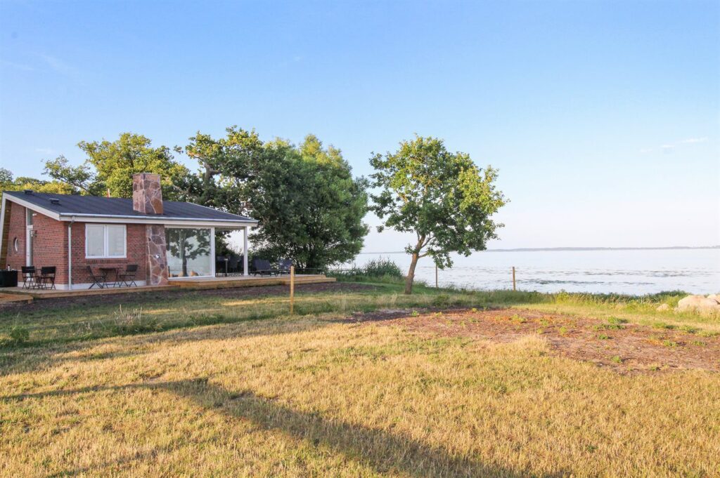 Träumen Sie von einem unvergesslichen Urlaub direkt am Meer? Dann ist dieses charmante Ferienhaus in Dänemark, genauer gesagt in Oure, genau das Richtige für Sie! Nur 10 Meter trennen Sie hier vom sanften Rauschen der Wellen und dem feinen Sandstrand – ein Paradies für Badefreunde und Naturliebhaber.

Unser Küstenhaus bietet mit 45 m² Wohnfläche und einem 320 m² großen Grundstück genügend Platz für bis zu 4 Personen. Das 2018 erbaute Haus ist modern und komfortabel eingerichtet. Genießen Sie entspannte Abende vor dem Kaminofen oder auf der 50 m² großen, teilweise überdachten Terrasse. Ein Sandkasten sorgt für Spaß bei den kleinen Gästen.

Im Inneren erwartet Sie ein gemütliches Wohnambiente mit Fußbodenheizung, WLAN und einem Fernseher, der eine Vielzahl an dänischen, schwedischen, norwegischen und deutschen Sendern bietet. Für Unterhaltung sorgen zusätzlich eine Musikanlage sowie ein CD- und DVD-Spieler. Die voll ausgestattete Küche lässt keine Wünsche offen: Hier finden Sie einen Kühlschrank, einen Gefrierschrank, einen Geschirrspüler, eine Mikrowelle und 4 Induktions-Kochzonen.

Die beiden Schlafzimmer sind mit Doppelbetten ausgestattet und bieten Platz für erholsame Nächte. Das Badezimmer ist mit einer Dusche ausgestattet, und eine Waschmaschine sowie ein Trockner stehen ebenfalls zur Verfügung. Ein besonderes Highlight ist der traumhafte Meerblick, den Sie von Ihrem Urlaubsdomizil aus genießen können.

Dieses Strandhaus ist ideal für Familien oder Paare, die einen entspannten Urlaub suchen. Auch Ihr Haustier ist bei uns herzlich willkommen. Für zusätzlichen Komfort sorgt eine energiesparende Wärmepumpe.

Dänemark.de bietet Ihnen nicht nur dieses wunderschöne Ferienhaus, sondern auch eine Bestpreisgarantie und den Dänemark.de-Bonus bei jeder Buchung. Treten Sie unserer Community auf Instagram bei und profitieren Sie von Inspirationen, Gutscheinen und Gewinnspielen!

Bitte beachten Sie: Das Ferienhaus wird nicht an Jugendgruppen unter 25 Jahren vermietet. Rauchen ist im Haus nicht gestattet. Eine Endreinigung kann optional hinzugebucht werden.

Buchen Sie jetzt Ihr persönliches Paradies und erleben Sie einen unvergesslichen Urlaub in diesem wunderschönen Ferienhaus in Dänemark!